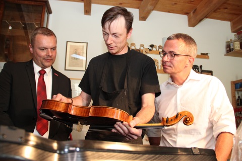 Besuch bei Geigenbauer Ian Crawford McWilliams (Mitte) mit Robert Wüst, Präsident der Handwerkskammer Potsdam (links) und Minister Albrecht Gerber (rechts auf dem Foto)